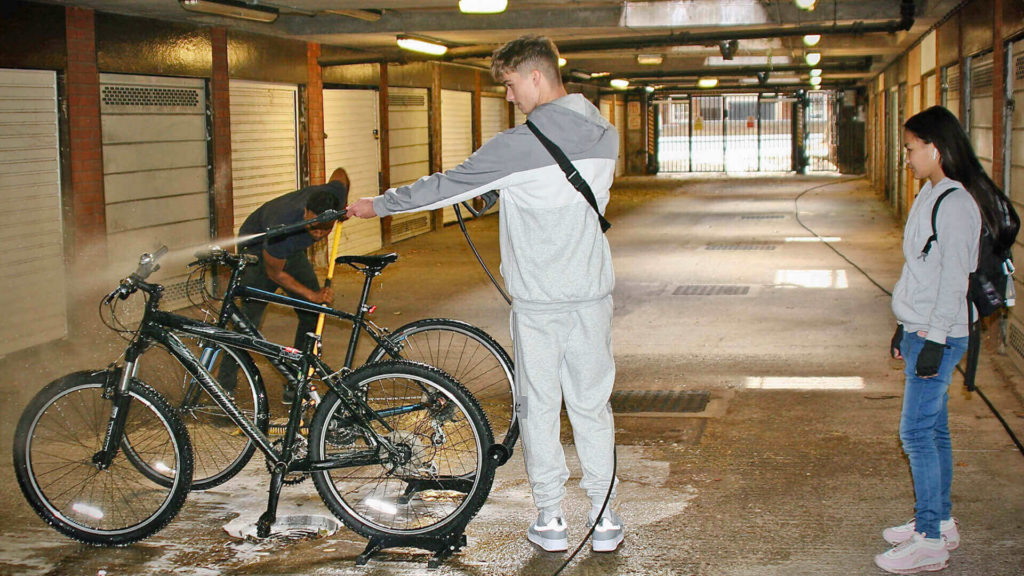 Young man cleaning a bicycle