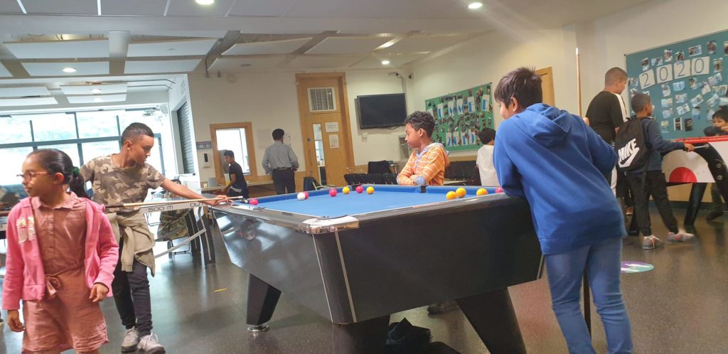 Children play pool indoors