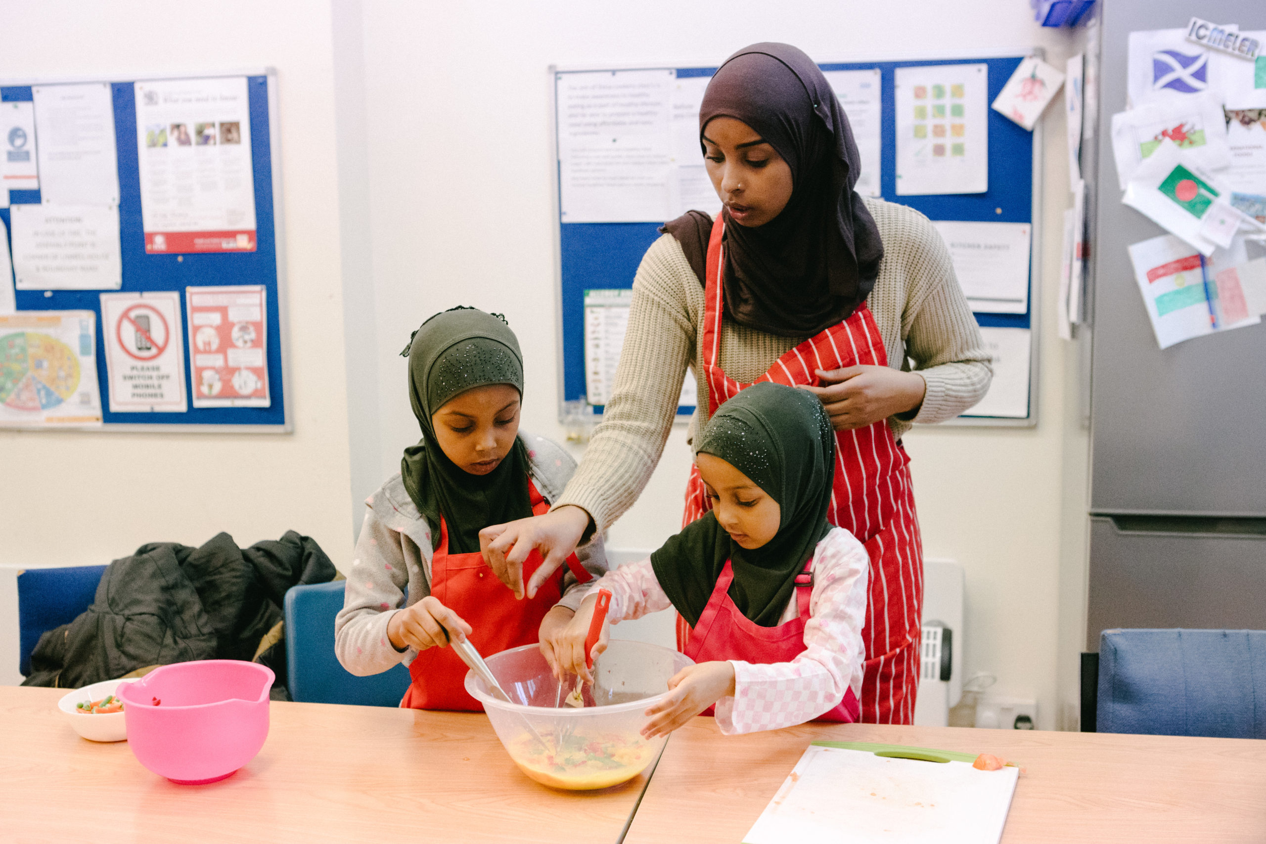 Woman cooks with her two children