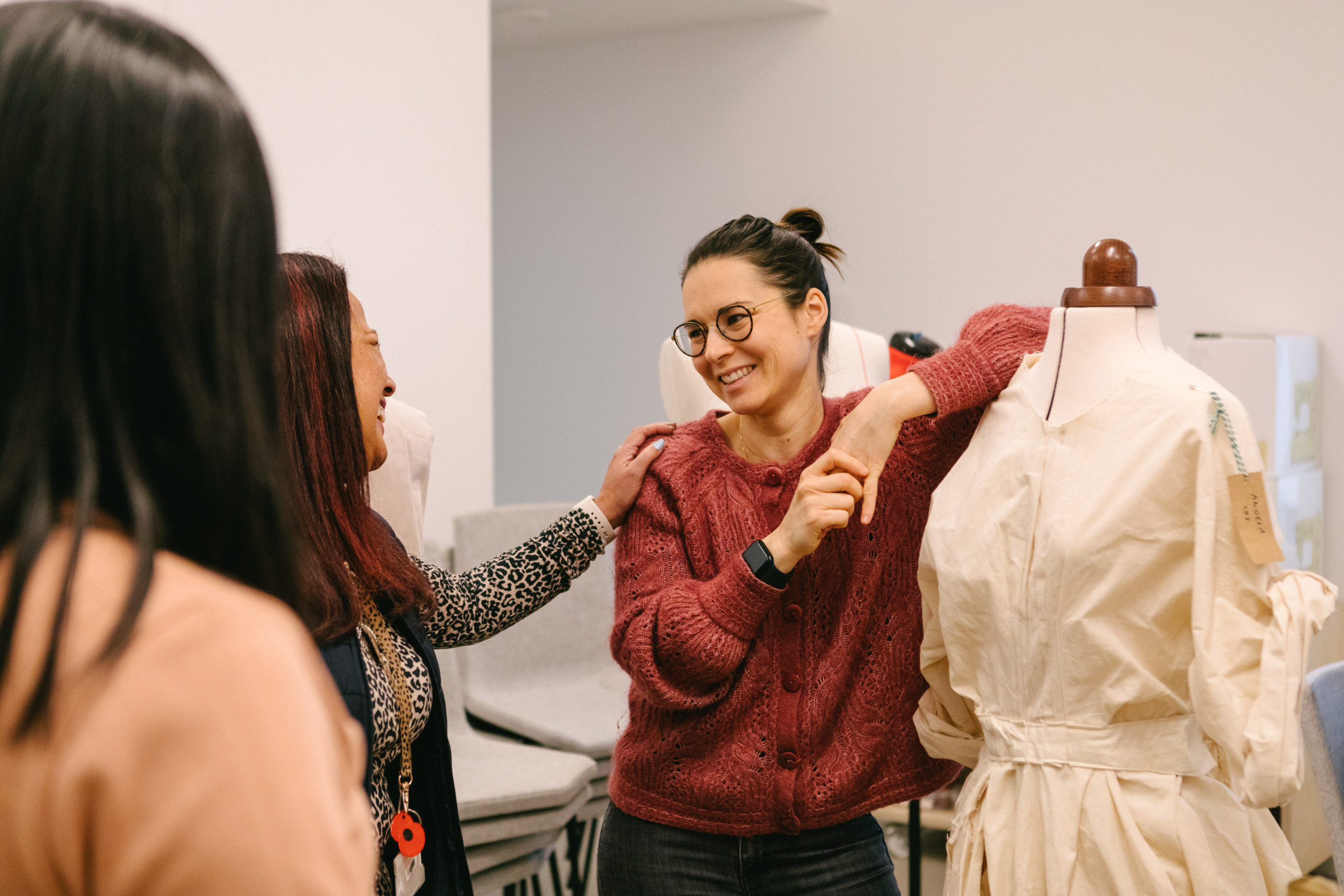 Woman stands leaning on a mannequin