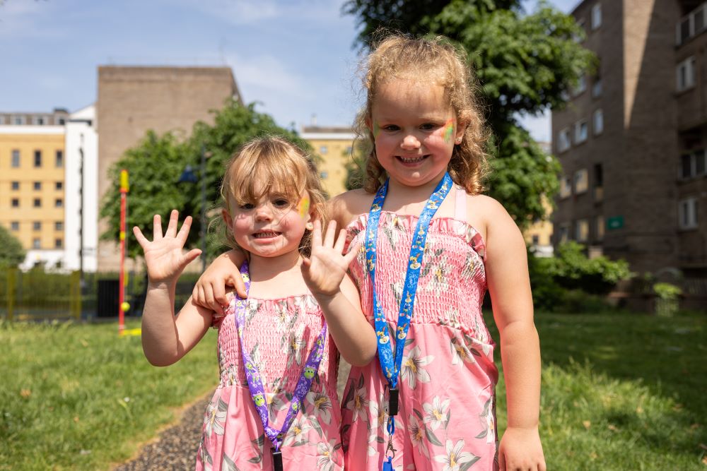 Two girls with face paint and medals in a sunny field