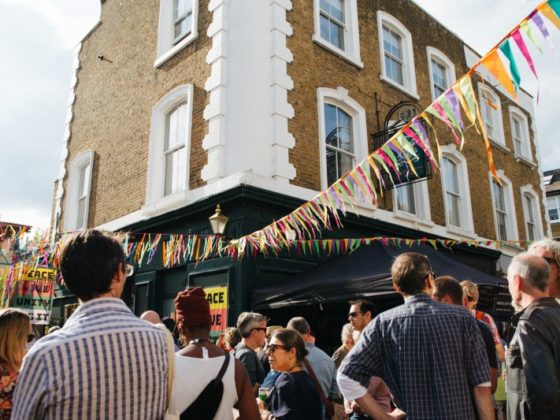 a crowd of people outside a building and some bunting