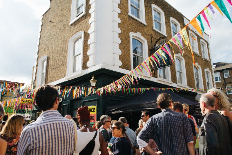 a crowd of people outside a building and some bunting