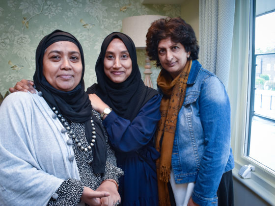 Momota, Bushra and Sajida stand together smiling