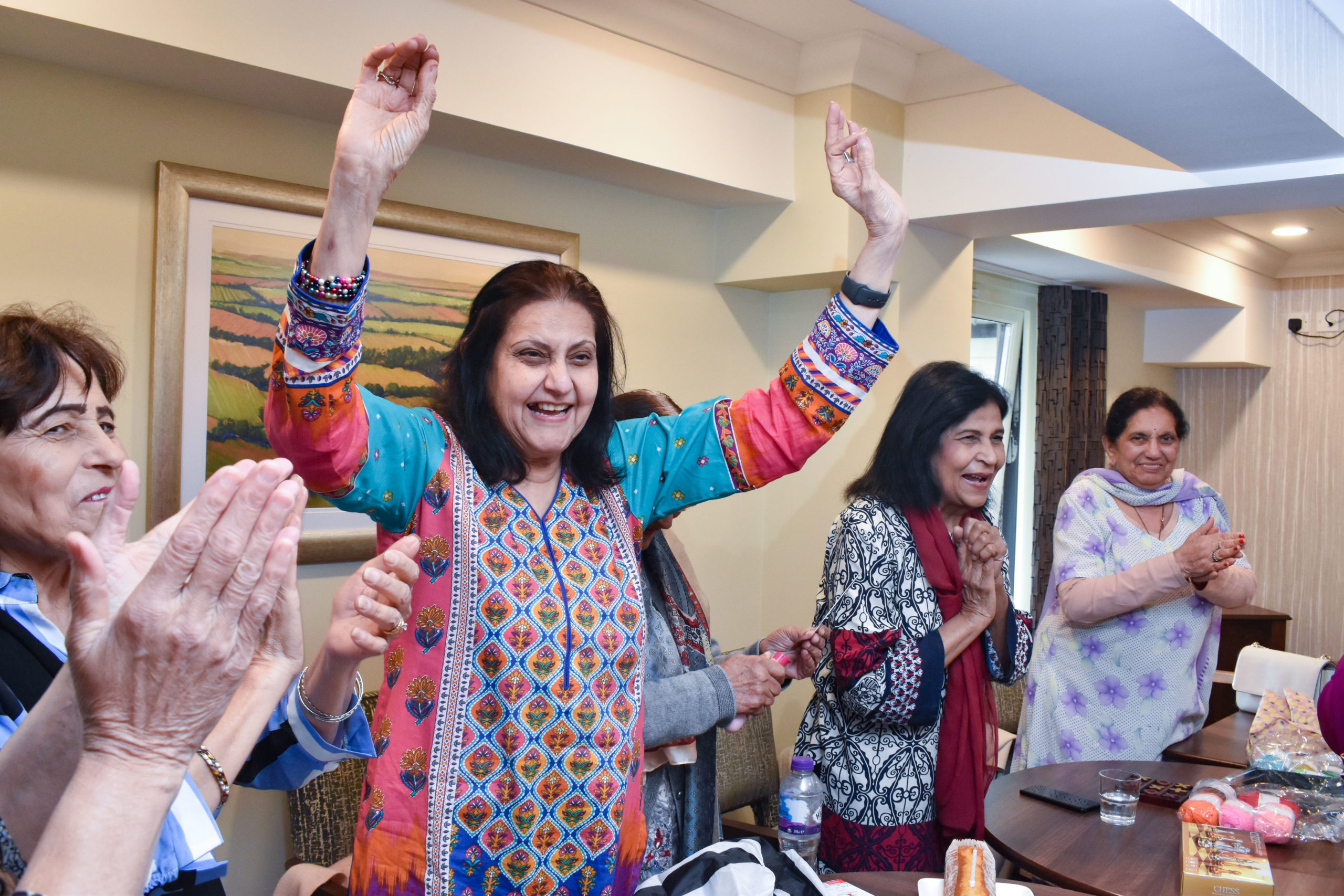 Henna members cheer and clap as they sing Happy Birthday to another member.