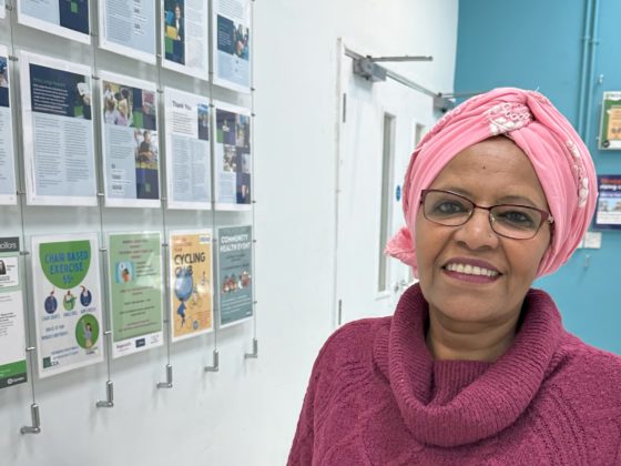 Khadija smiles at the camera standing inside one of QCCA's offices