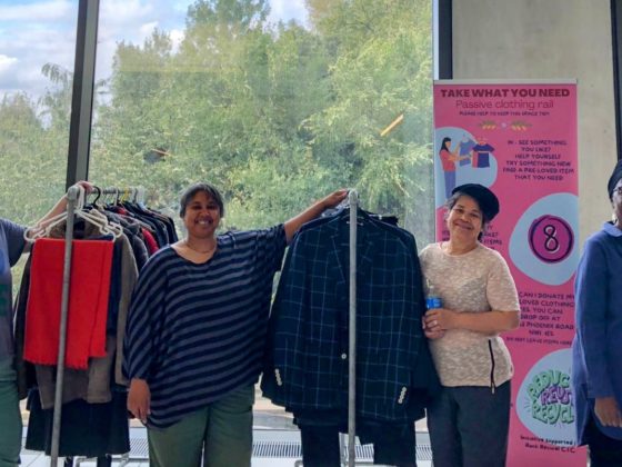 people standing next to clothes rails