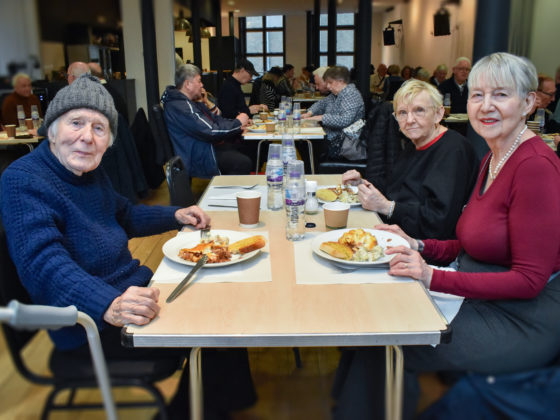 A man and two women enjoy their meals at the over 50s lunch club hosted by the Covent Garden Community Centre.