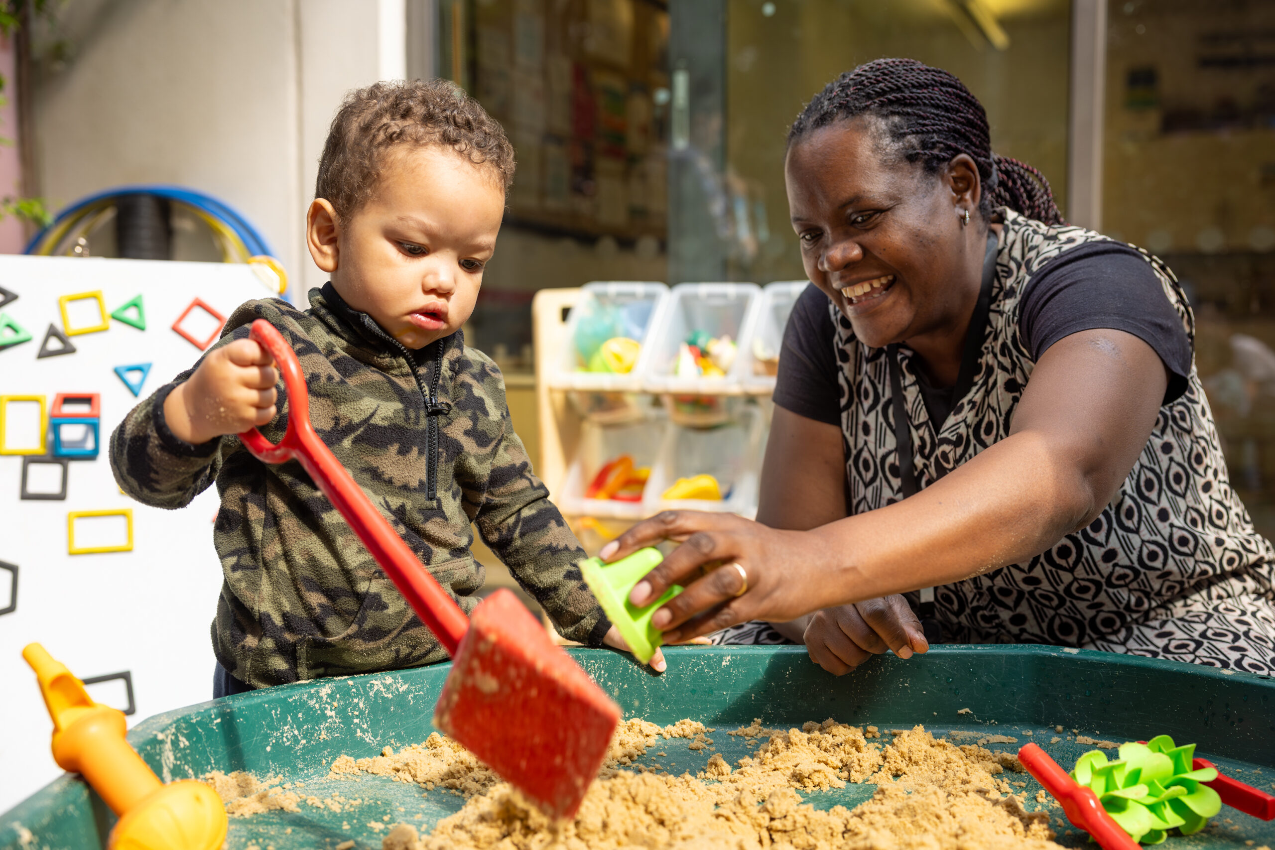 Woman and toddler playing with sand