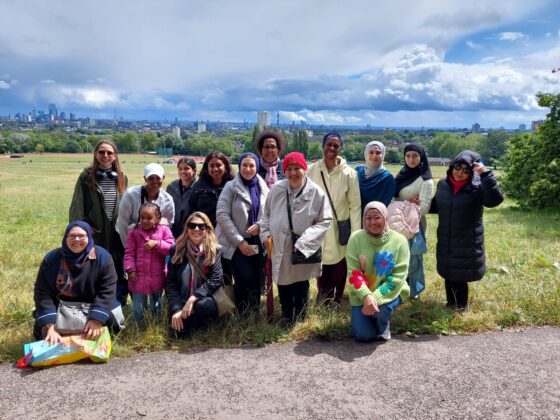 Lamigaa’s volunteer mentors and mentees come together for an Autumn Walk, they are photographed as a group.
