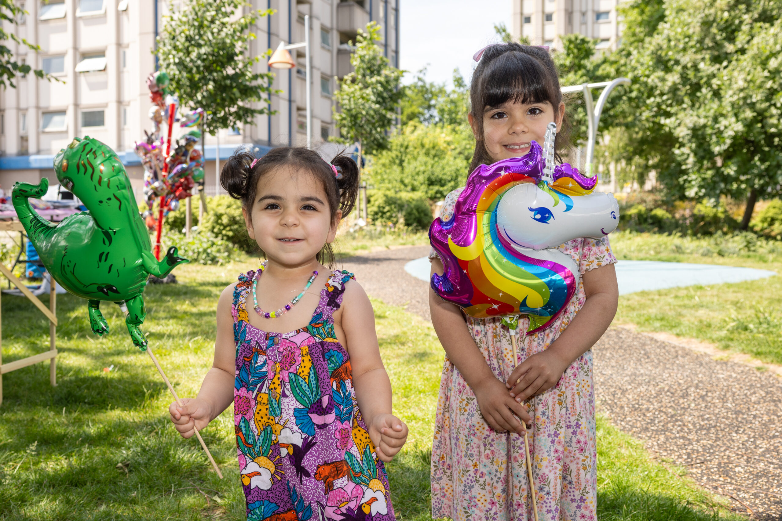 Two young girls holding balloons.
